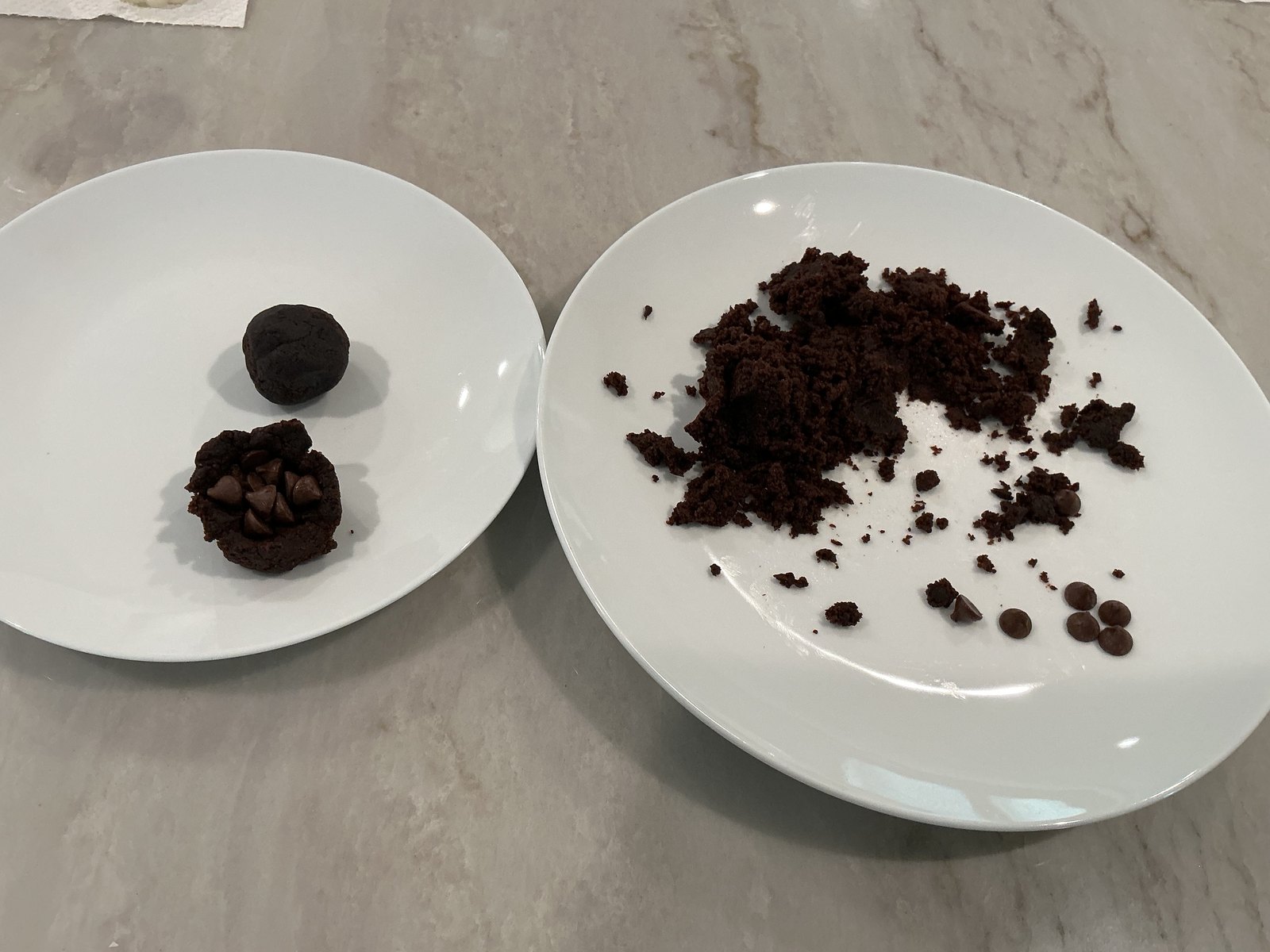 Crumbled prepared brownie on one plate and a compact brownie filling ball on another
